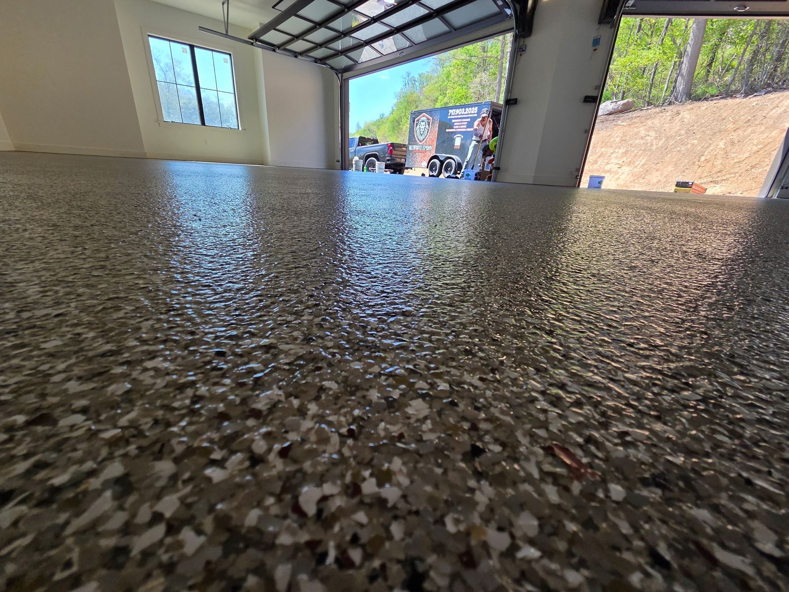 Grey flake floor in a residential garage with the door open