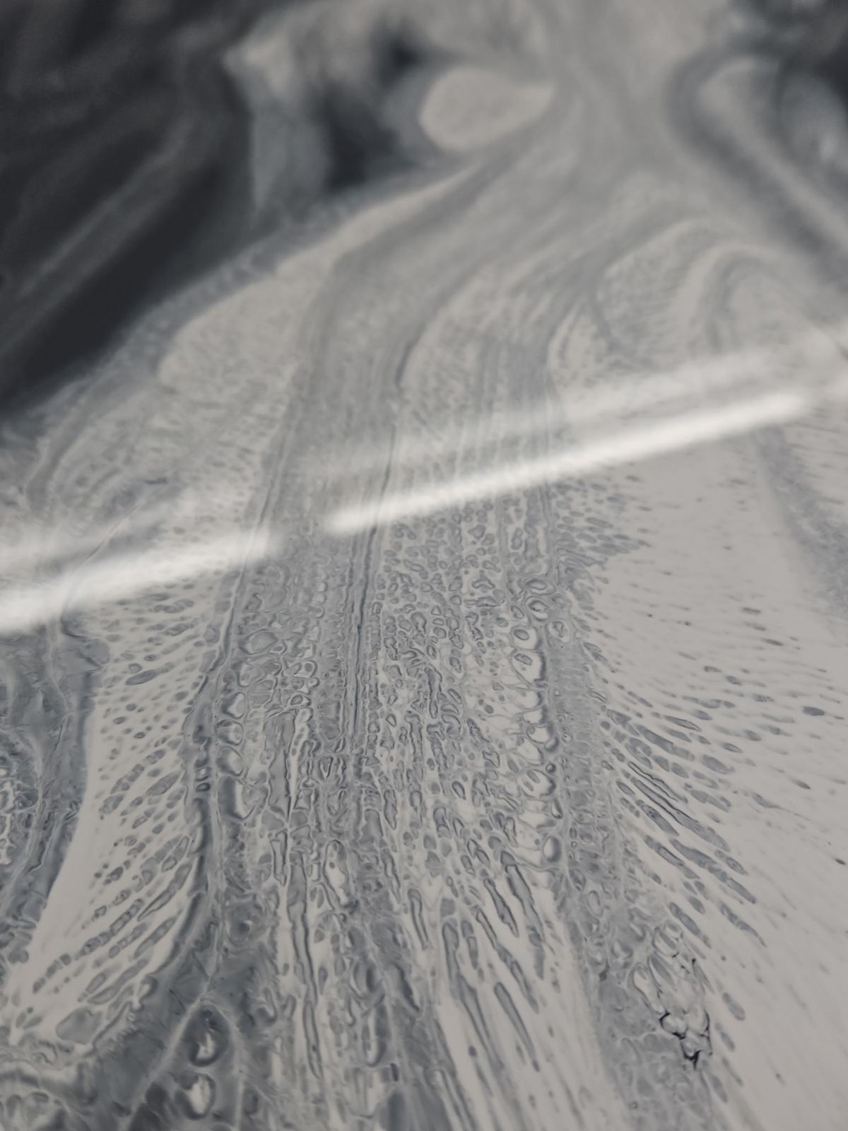 Metallic epoxy floor with a hand-worked grey and white marbled pour