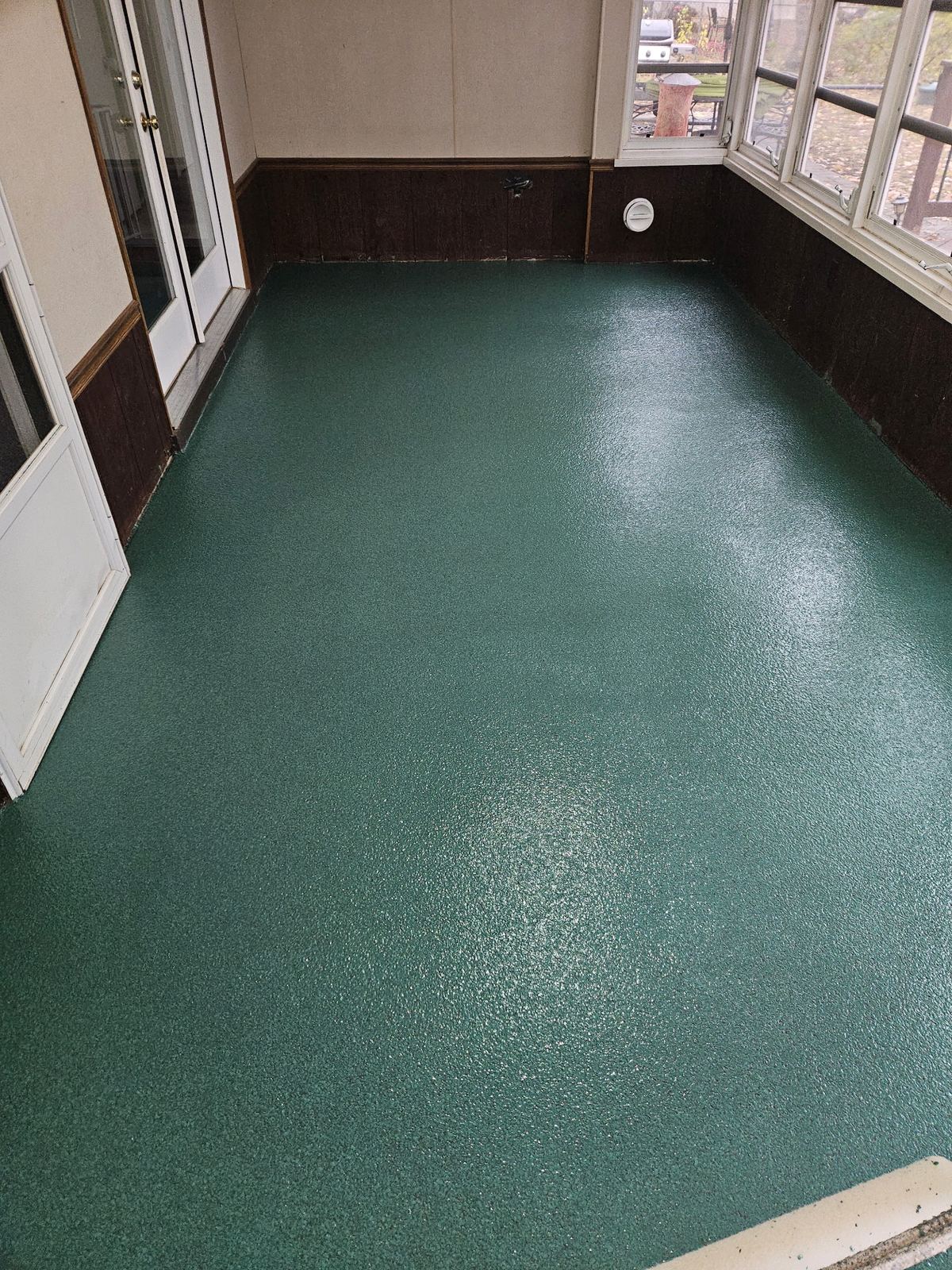 Teal solid colour floor coating in a finished interior room
