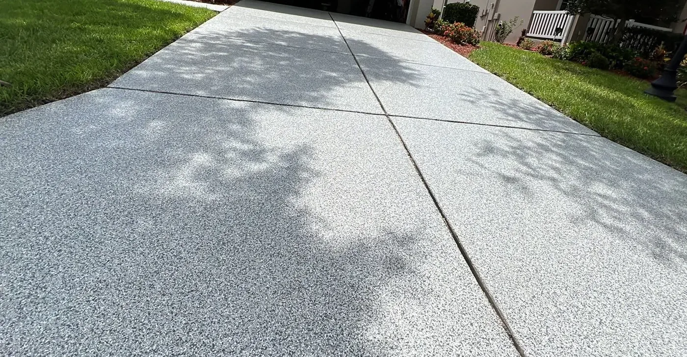 Light gray flake coating on outdoor concrete between two lawns